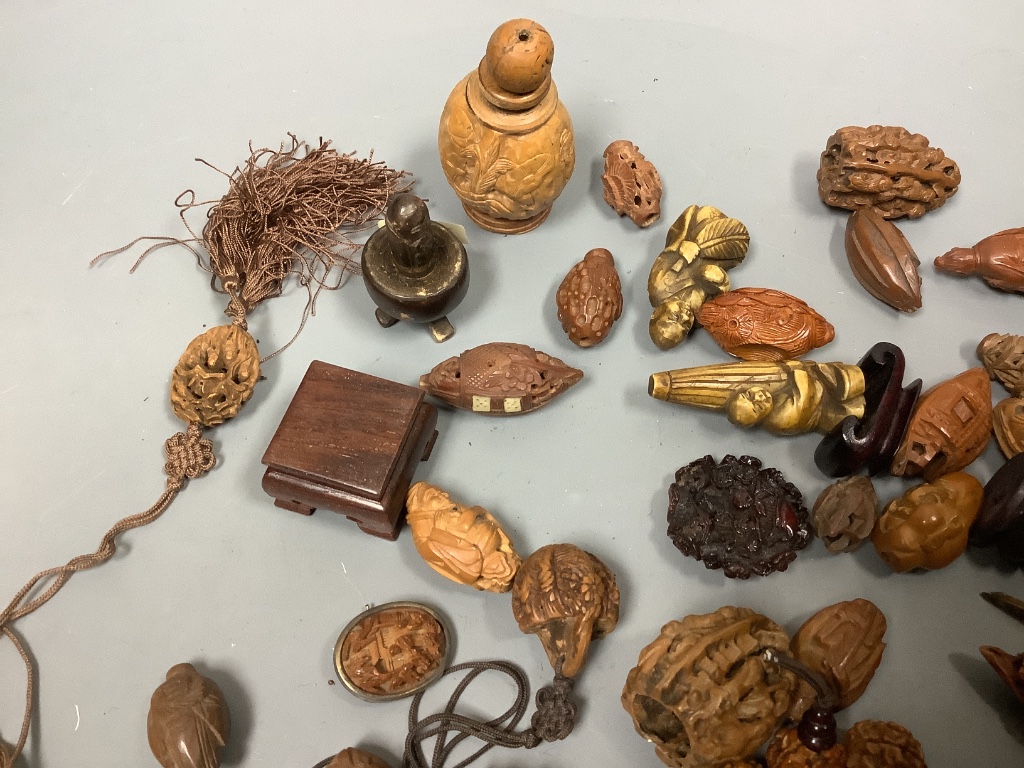 An assortment of Chinese peach stone and a nut carvings